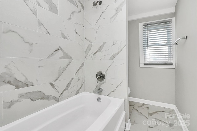 bathroom with baseboards, marble finish floor, and washtub / shower combination