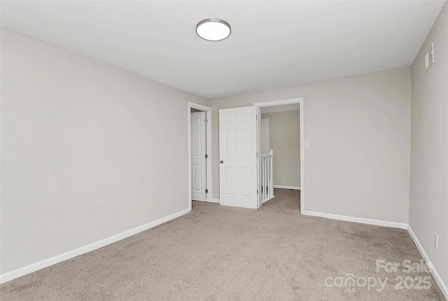 carpeted spare room with baseboards