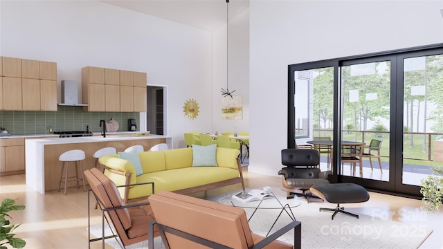 living room featuring a towering ceiling and light wood-type flooring