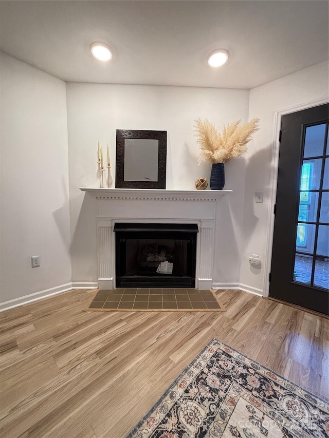 details featuring hardwood / wood-style flooring and a tile fireplace