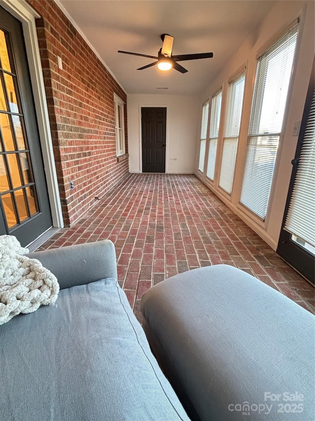 sunroom / solarium featuring ceiling fan