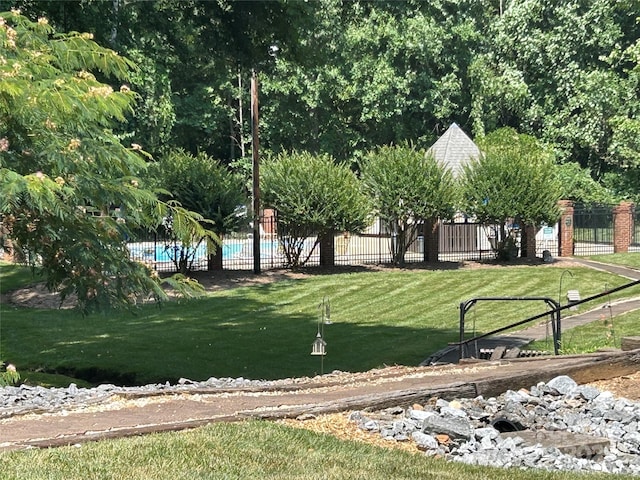 surrounding community featuring a swimming pool and a lawn