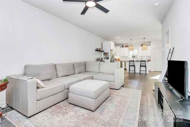 living room featuring ceiling fan and light wood-type flooring