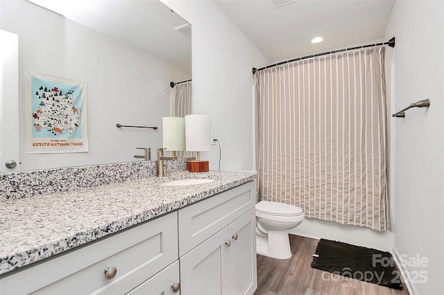 bathroom featuring vanity, hardwood / wood-style floors, and toilet