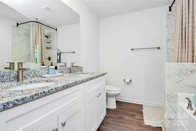 bathroom with hardwood / wood-style flooring, vanity, walk in shower, and toilet