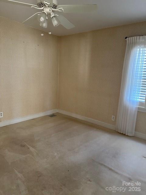 carpeted spare room featuring ceiling fan