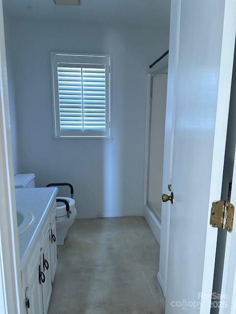 bathroom with vanity, a shower, and toilet