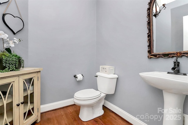 bathroom with hardwood / wood-style flooring, sink, and toilet