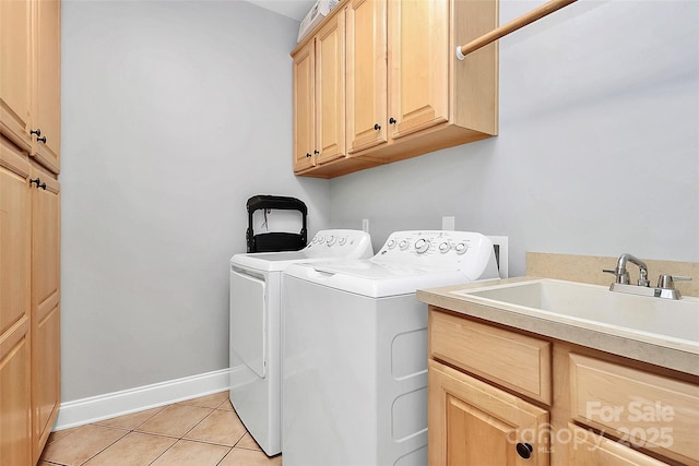 laundry room with cabinets, washer and clothes dryer, sink, and light tile patterned floors