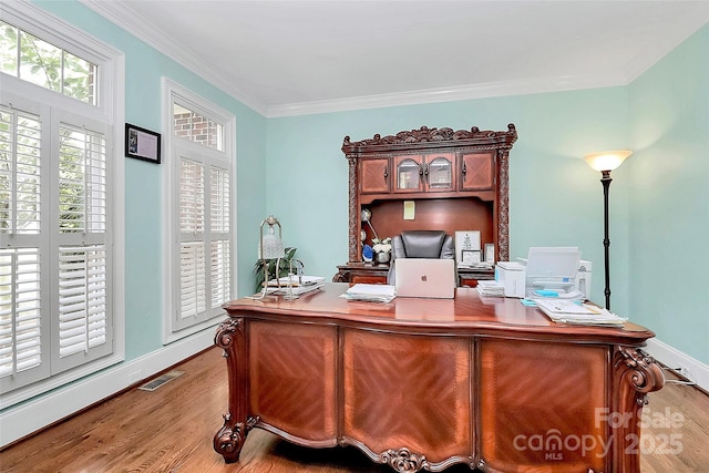 office space with ornamental molding and light wood-type flooring