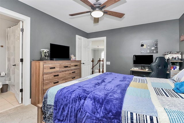 bedroom with ceiling fan, ensuite bath, and carpet flooring