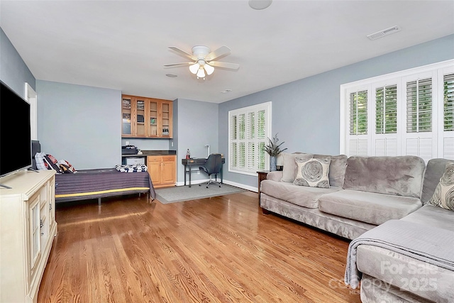 living room featuring ceiling fan and light hardwood / wood-style flooring