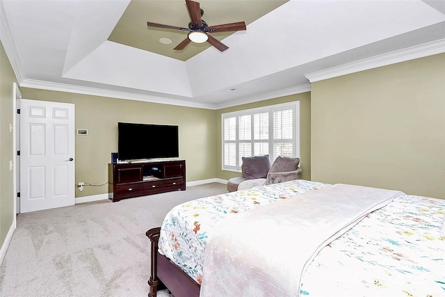 carpeted bedroom with a tray ceiling, ornamental molding, and ceiling fan