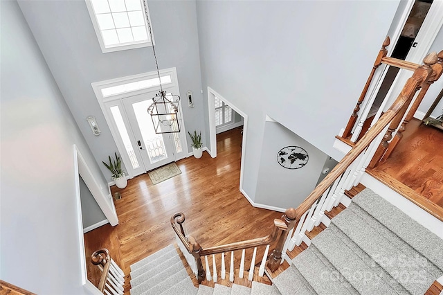 foyer entrance featuring hardwood / wood-style flooring, a chandelier, and a high ceiling