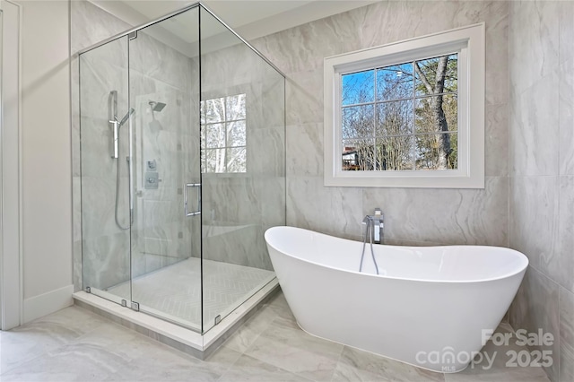 bathroom with tile walls and shower with separate bathtub