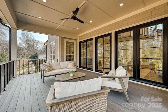 wooden terrace featuring ceiling fan and an outdoor living space