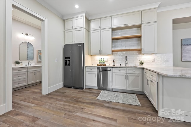 kitchen featuring refrigerator with ice dispenser, sink, dishwasher, tasteful backsplash, and white cabinets