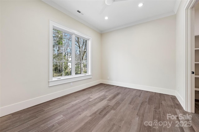 empty room featuring hardwood / wood-style floors, ornamental molding, and ceiling fan