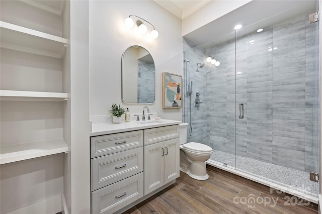 bathroom featuring vanity, hardwood / wood-style floors, a shower with door, and toilet