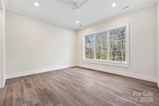 empty room featuring ornamental molding, light hardwood / wood-style floors, and ceiling fan