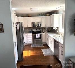 kitchen with sink, stainless steel appliances, dark hardwood / wood-style floors, and white cabinets