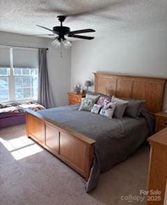 carpeted bedroom featuring ceiling fan and a textured ceiling