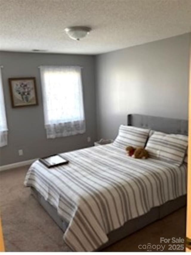 bedroom with carpet flooring and a textured ceiling