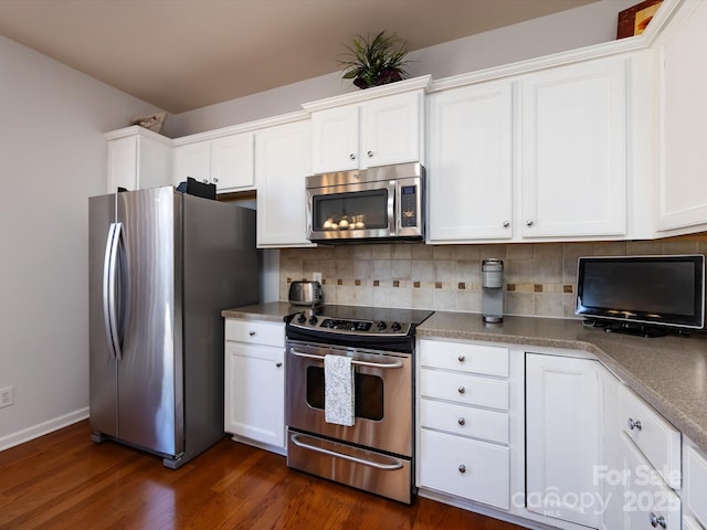 kitchen with baseboards, white cabinets, appliances with stainless steel finishes, dark wood-style floors, and tasteful backsplash