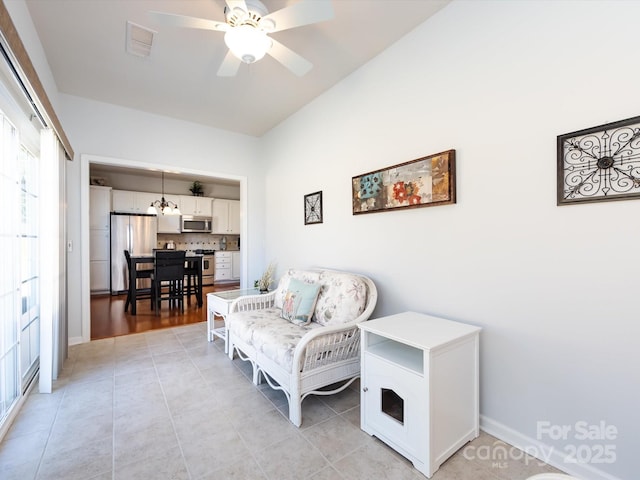 sitting room featuring light tile patterned floors, ceiling fan with notable chandelier, and visible vents