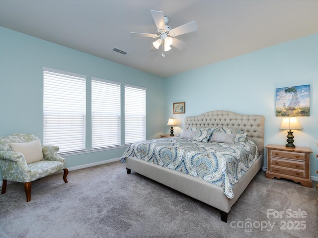 carpeted bedroom with a ceiling fan, visible vents, and baseboards