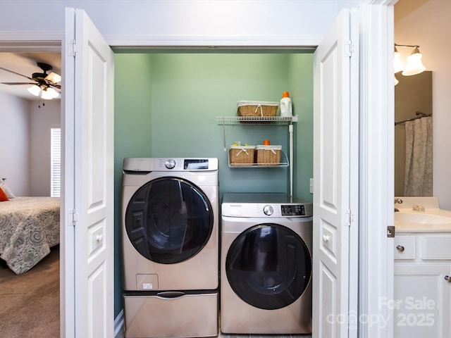 clothes washing area with ceiling fan, laundry area, independent washer and dryer, and a sink