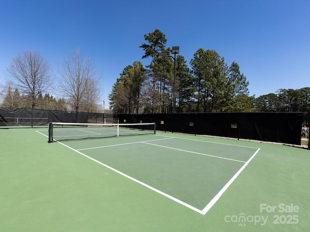 view of tennis court with community basketball court and fence