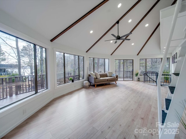 unfurnished sunroom with lofted ceiling with beams, a wealth of natural light, and ceiling fan