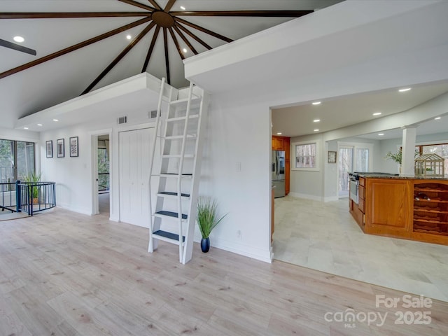 unfurnished living room featuring high vaulted ceiling and light hardwood / wood-style floors