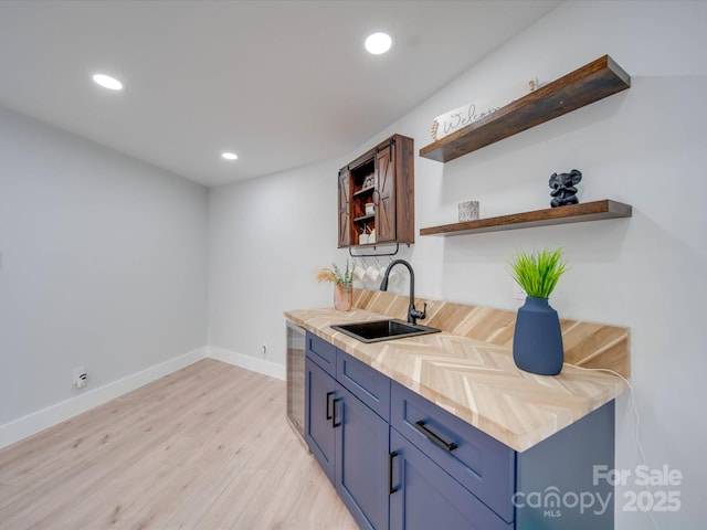 bar featuring sink and light wood-type flooring