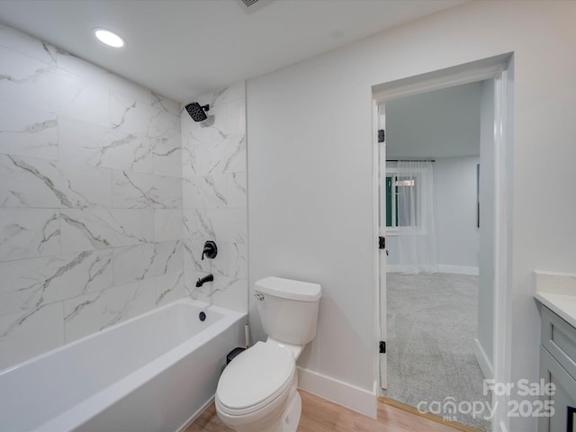 full bathroom featuring vanity, wood-type flooring, toilet, and tiled shower / bath