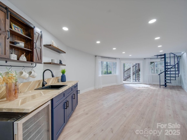 kitchen with wine cooler, sink, and light hardwood / wood-style floors