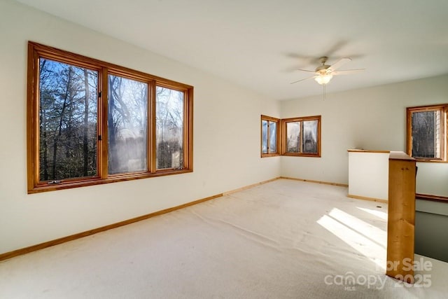 carpeted spare room with ceiling fan