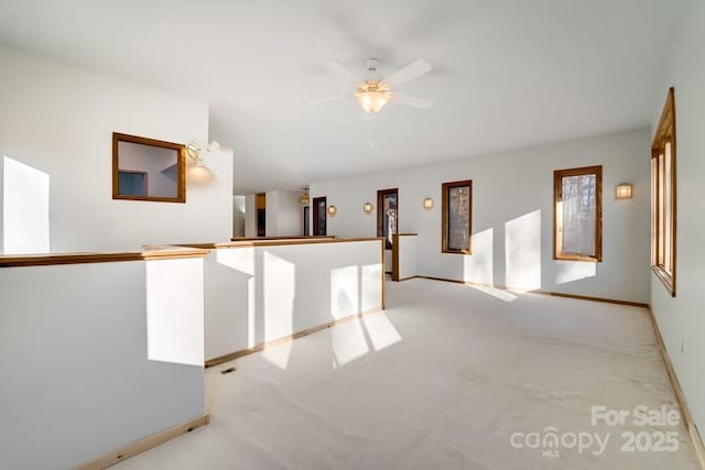 interior space with ceiling fan and light carpet