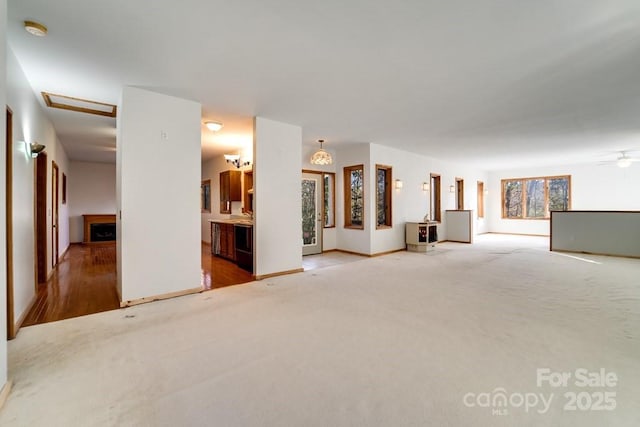 unfurnished living room with ceiling fan and carpet flooring