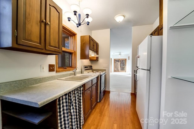 kitchen with ceiling fan with notable chandelier, sink, white refrigerator, electric range, and light hardwood / wood-style floors