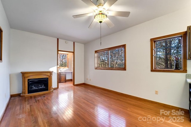 unfurnished living room with ceiling fan and wood-type flooring