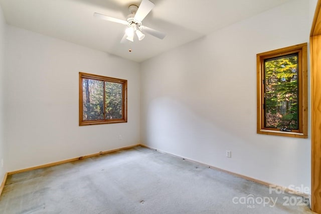 unfurnished room with ceiling fan and carpet