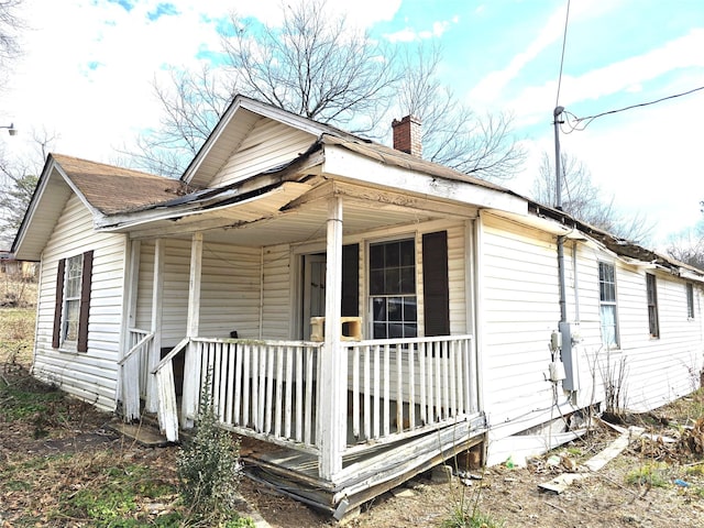 view of side of property with covered porch