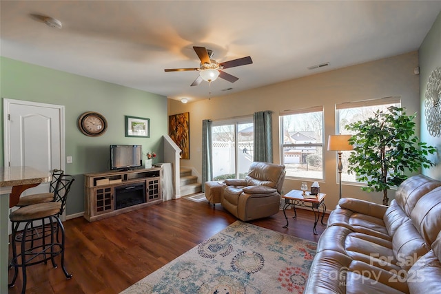 living room featuring dark wood-type flooring and ceiling fan