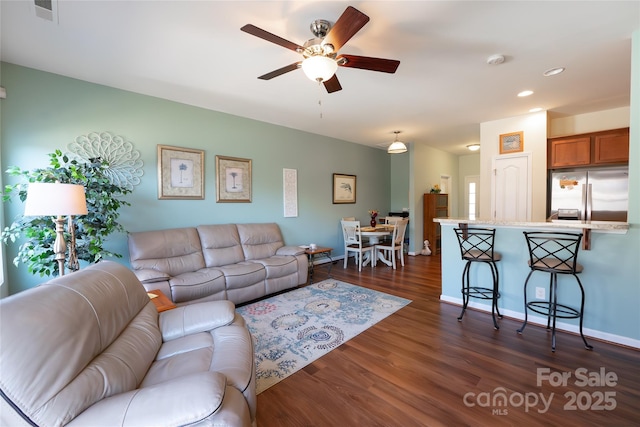 living room featuring dark wood-type flooring and ceiling fan