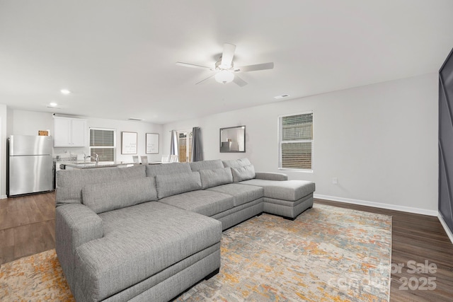 living room with wood-type flooring and ceiling fan