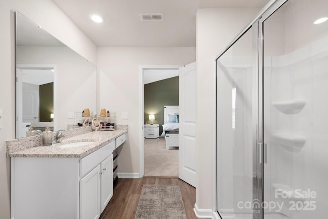 bathroom featuring vanity, hardwood / wood-style flooring, and walk in shower