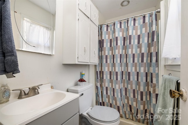 bathroom featuring vanity, toilet, and curtained shower