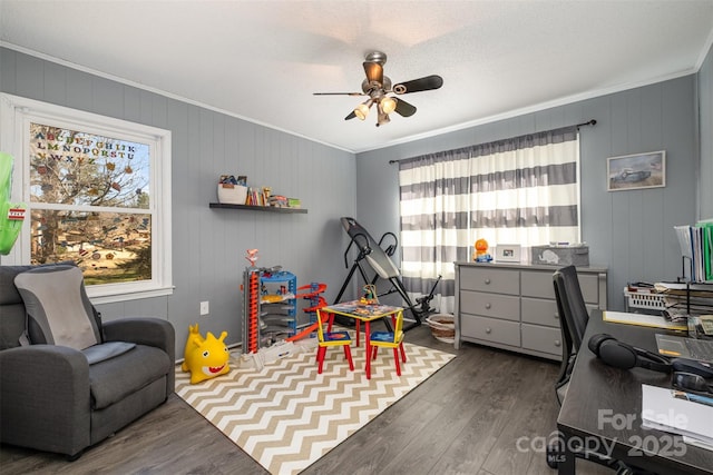 game room with dark hardwood / wood-style flooring, ornamental molding, and ceiling fan